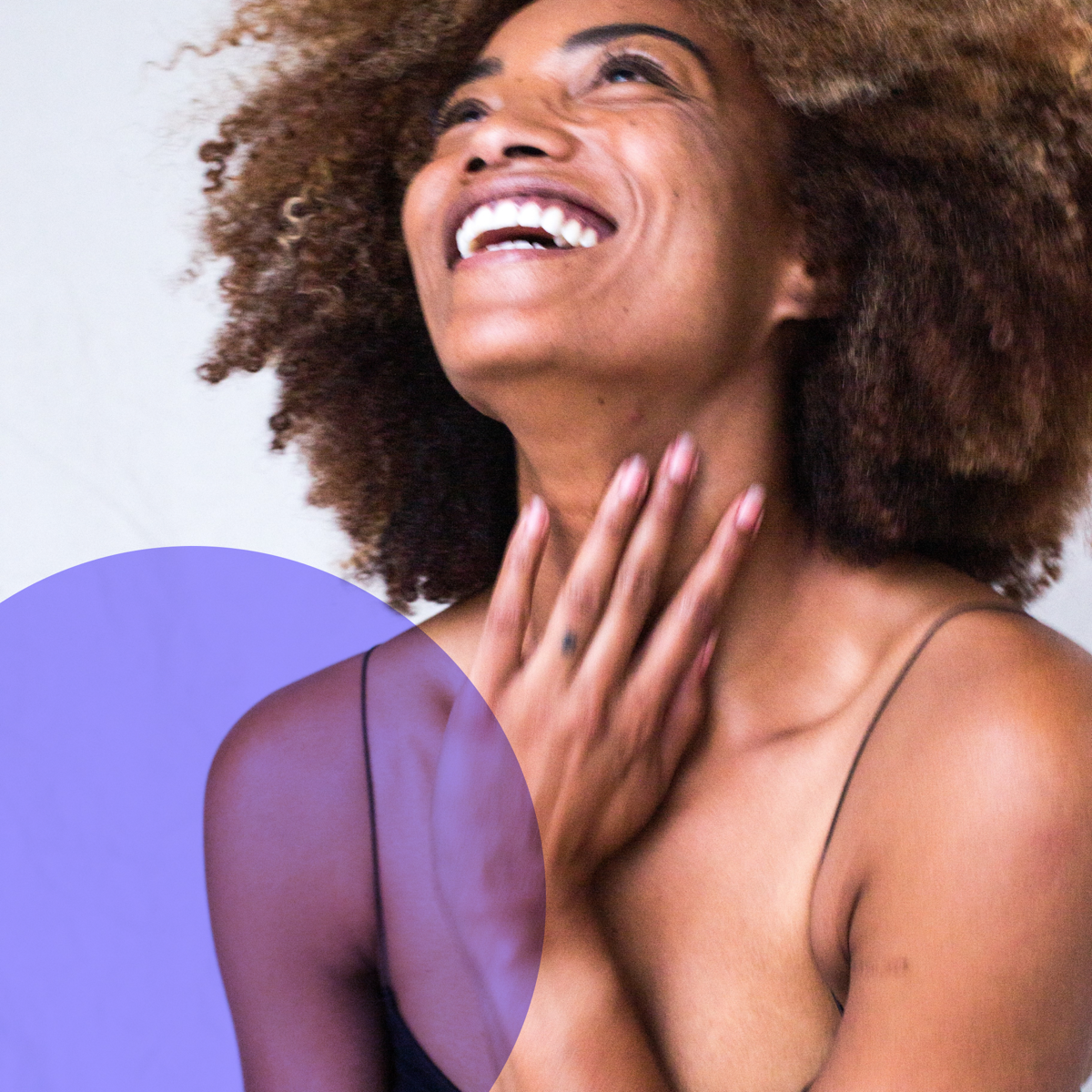 A smiling woman touching her neck